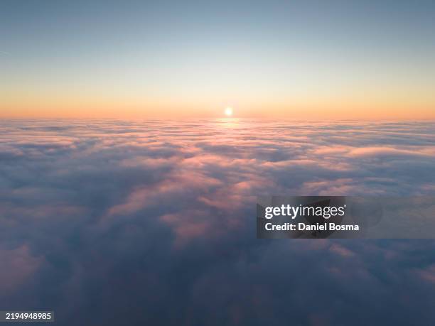 flying above the fog during sunset seen from a drone - bovenop stockfoto's en -beelden