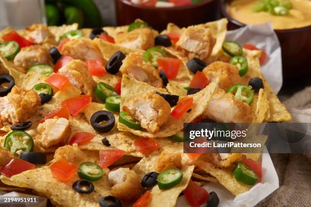 crispy chicken tender nachos - cheese sauce stock pictures, royalty-free photos & images