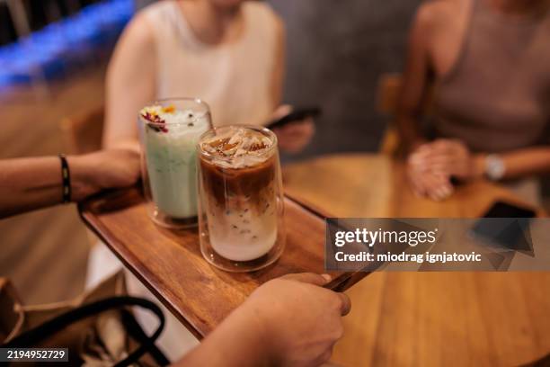 camarera sirviendo bebidas a las mujeres en el café - café bar fotografías e imágenes de stock