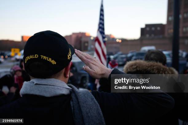 Supporter of U.S. President Donald Trump salutes during the Pledge of Allegiance while gathering outside the DC Central Detention Facility on January...