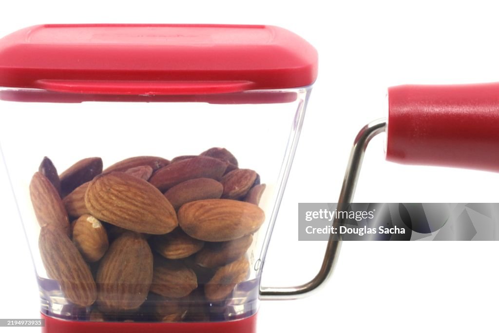 Almond nuts in a manual kitchen grinder
