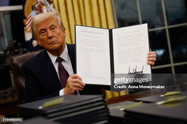 President Donald Trump signs executive orders in the Oval Office on January 20, 2025 in Washington, DC. Trump takes office for his second term as the...