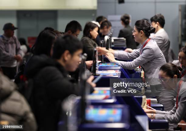 Passengers check in at the counter of Beijing Capital International Airport during the Spring Festival travel rush on January 20, 2025 in Beijing,...