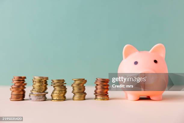 piggy bank and coins - savings stock pictures, royalty-free photos & images