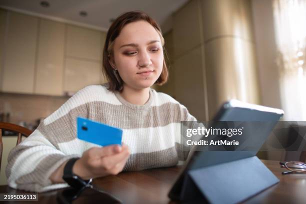 young woman with credit card and digital tablet at home - credit card art stock pictures, royalty-free photos & images