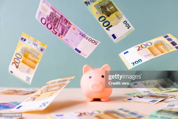 piggy bank and falling european union currency - wealth stock pictures, royalty-free photos & images