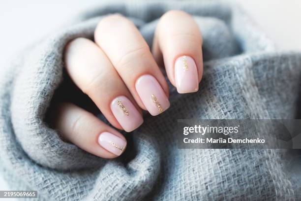 hand with pink gel fingernails with glitter - manicura de diseño fotografías e imágenes de stock