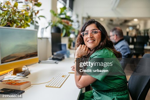 Mulher indiana do Meados de-adulto que trabalha no computador no prédio de escritórios em Sydney em Austrália Mulher indiana do Meados de-adulto que trabalha no computador no prédio de escritórios em Sydney em Austrália