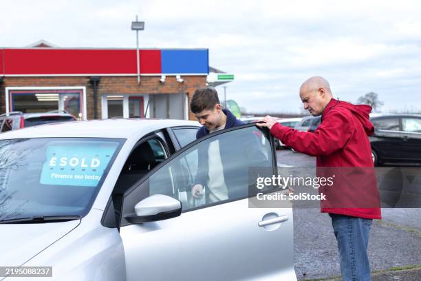 taking a look inside his first car - tweedehands autoverkoop stockfoto's en -beelden