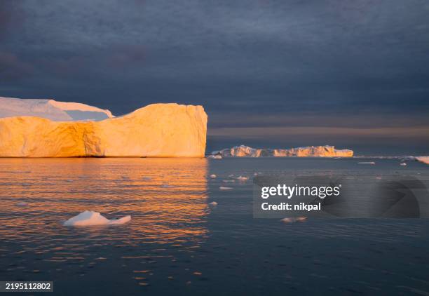 paysage avec de beaux icebergs roses frappés par le soleil couchant dans la baie de disko à ilulissat, groenland - arctique photos et images de collection