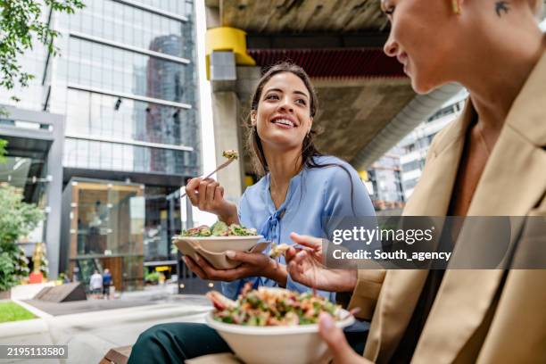 businesswomen enjoying lunch outdoors in sydney's bustling city atmosphere - lunchpauze stockfoto's en -beelden