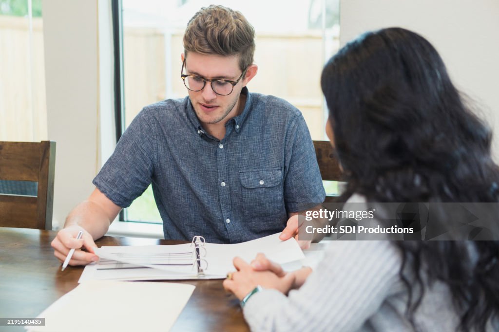 Young Man and Woman in Discussion, Reviewing Documents