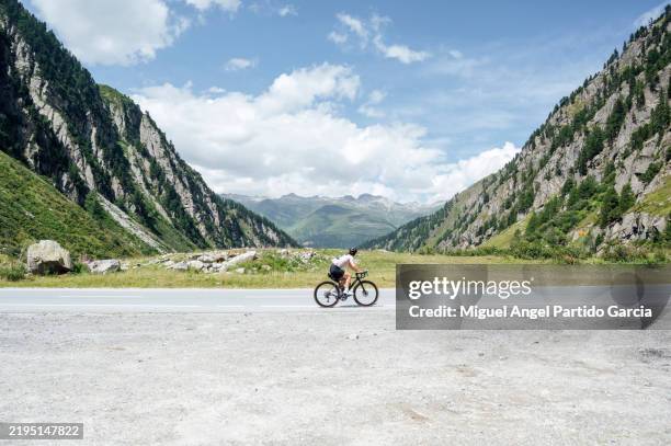 cyclist riding a road bike on a scenic mountain road - bicicleta de corrida imagens e fotografias de stock