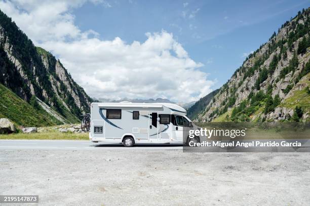 motorhome passing through a mountain road - camper van stock pictures, royalty-free photos & images