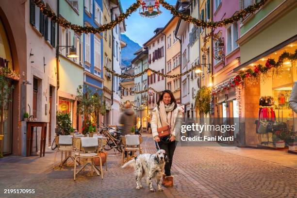 lady with dog in bolzano christmas market - bolzano stock pictures, royalty-free photos & images