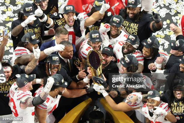 The Ohio State Buckeyes hoist the trophy after beating the Notre Dame Fighting Irish 34-23 in the 2025 CFP National Championship at the Mercedes-Benz...