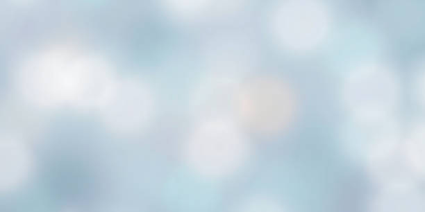 Abstract soft winter background with blurred light bokeh effect. Gentle frosty texture in light blue and white tones. Calm serene winter mood for creative seasonal projects and design