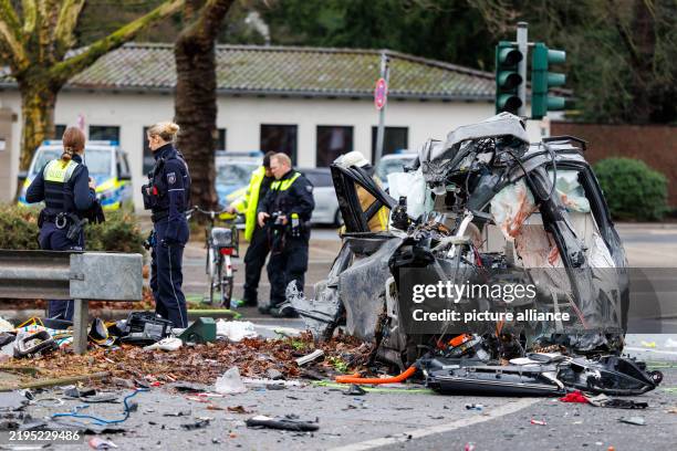 January 2025, Duesseldorf: The wrecked BMW X5 lies on the sidewalk, police officers in the background secure evidence. Photo: Christoph Reichwein/dpa...
