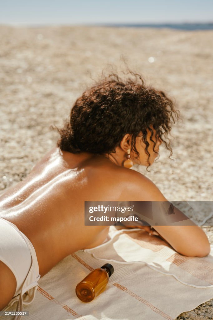Woman Relaxing on Sunny Beach in Summer with Sun Lotion