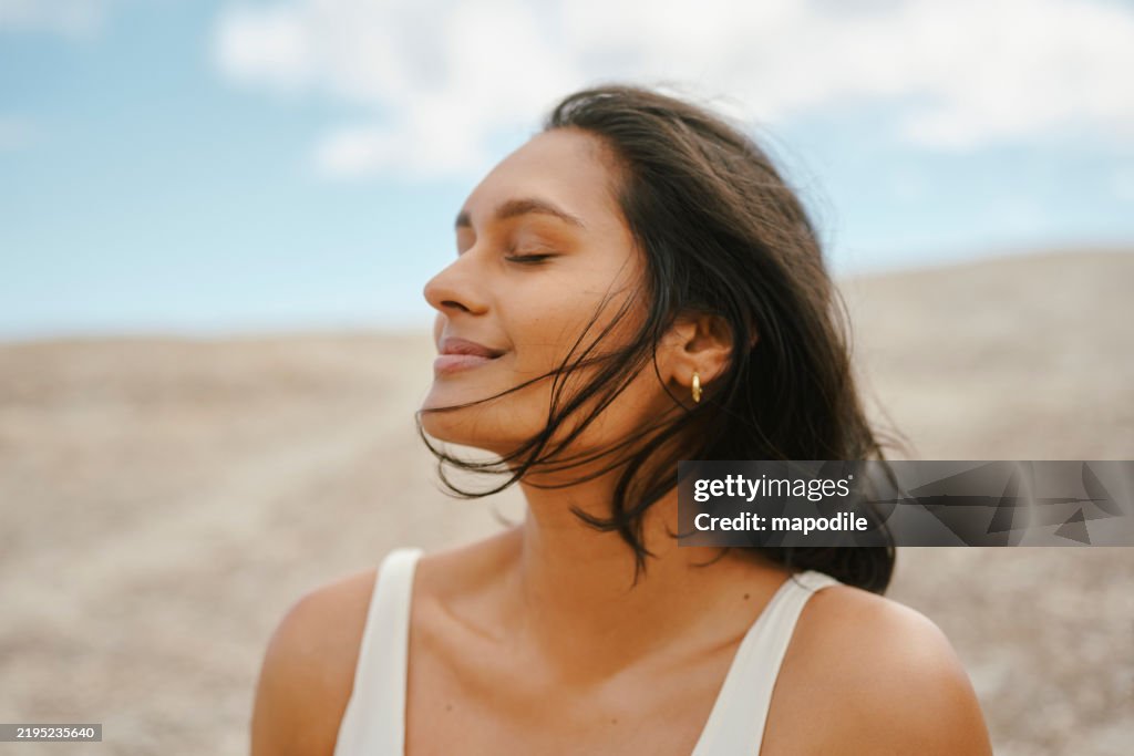 Mulher com pele brilhante desfrutando de uma brisa tranquila em um ambiente natural sereno