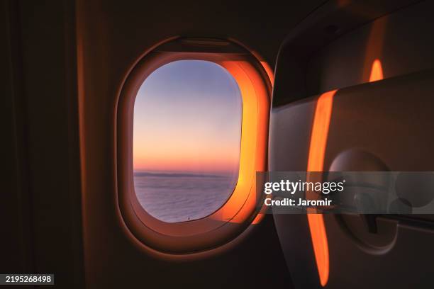 view through airplane window during flight at sunrise - flugzeugsitz stock-fotos und bilder