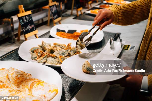 ravioli asiatici al ristorante. primo piano di gnocchi di serraggio a mano. - bollito foto e immagini stock