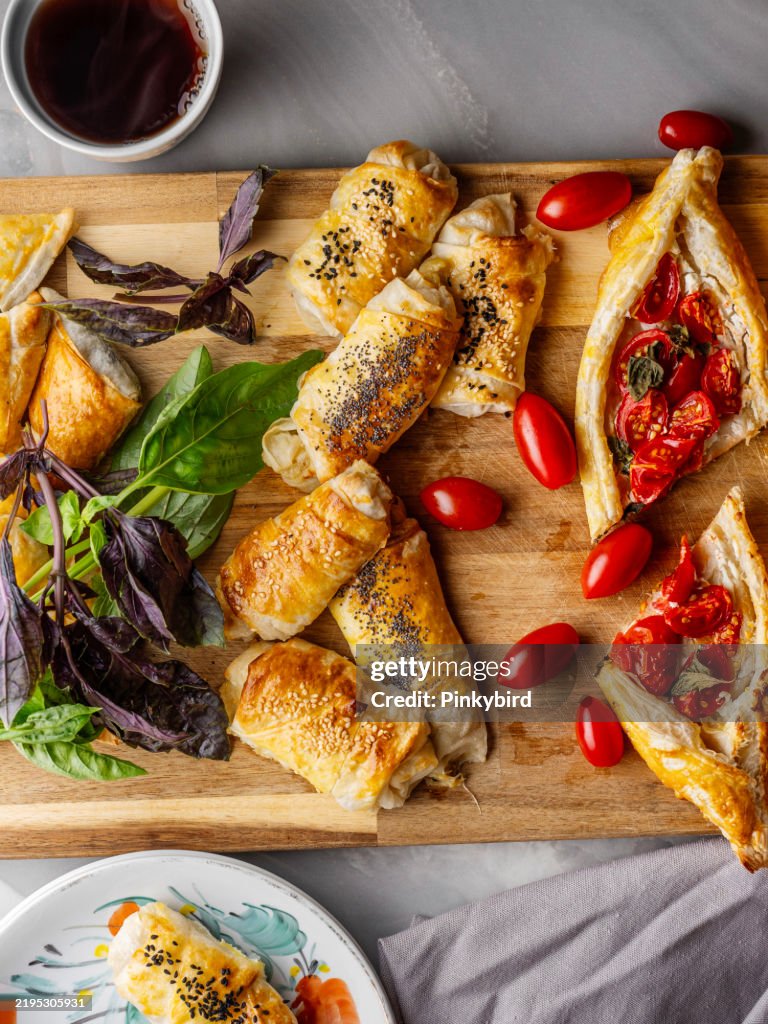 Turkish pita. Turkish Pide. Margherita Flat Bread Pizza. Turkish pide with pastry on the board. Homemade feta cheese puff pastry. Puff pastry pie with tomatoes and basil. Savory Tarts. Tomato Quiche. Tomato Tart. Delicious fresh cheese pita.