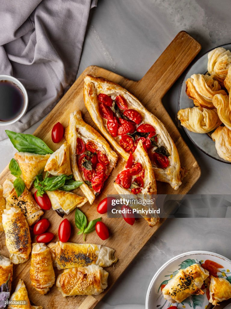 Turkish pita. Turkish Pide. Margherita Flat Bread Pizza. Turkish pide with pastry on the board. Homemade feta cheese puff pastry. Puff pastry pie with tomatoes and basil. Savory Tarts. Tomato Quiche. Tomato Tart. Delicious fresh cheese pita.