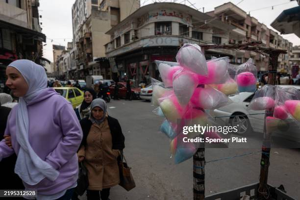 People walk through a shopping district in the city of Homs on January 22, 2025 in Homs, Syria. Homs, the country’s third-largest city, has a mixed...