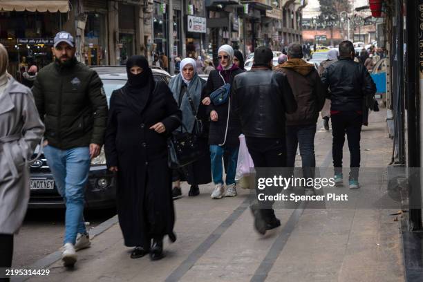 People walk through a shopping district in the city of Homs on January 22, 2025 in Homs, Syria. Homs, the country’s third-largest city, has a mixed...