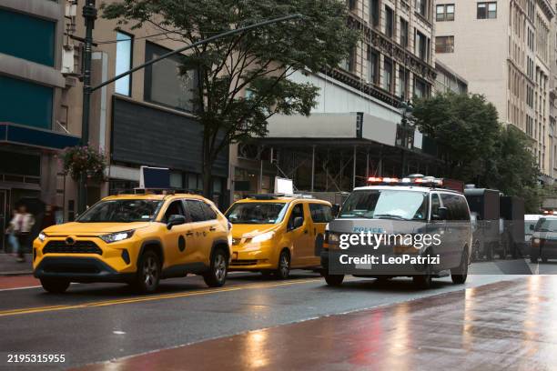 furgone della polizia e taxi giallo a new york - nypd vans foto e immagini stock