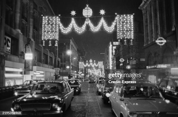 Traffic on Oxford Street with its Christmas lights illuminated at night, London, November 23rd 1966.