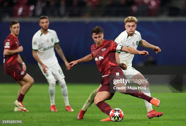 Willi Orban of RB Leipzig passes the ball whilst under pressure from Conrad Harder of Sporting CP during the UEFA Champions League 2024/25 League...