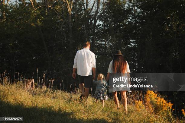 family walking outside - côte à côte photos et images de collection