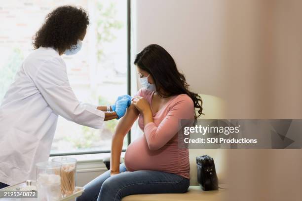 pregnant woman receiving covid-19 vaccine - covid 19 vaccine stock pictures, royalty-free photos & images