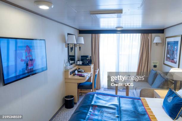 Britannias club balcony stateroom with king size bed and furnishings on Queen Elizabeth cruise ship.