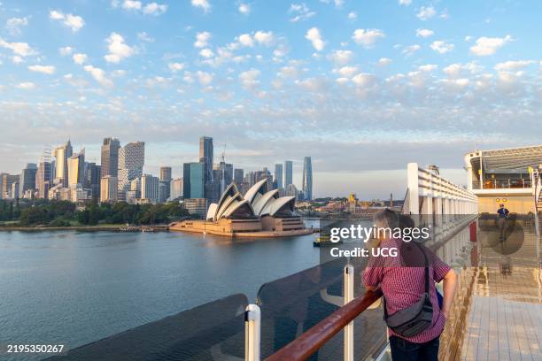 Passengers on board Cunard Queen Elizabeth cruise ship view the Sydney Opera House and Sydney city center as the cruise ship approaches Circular Quay...