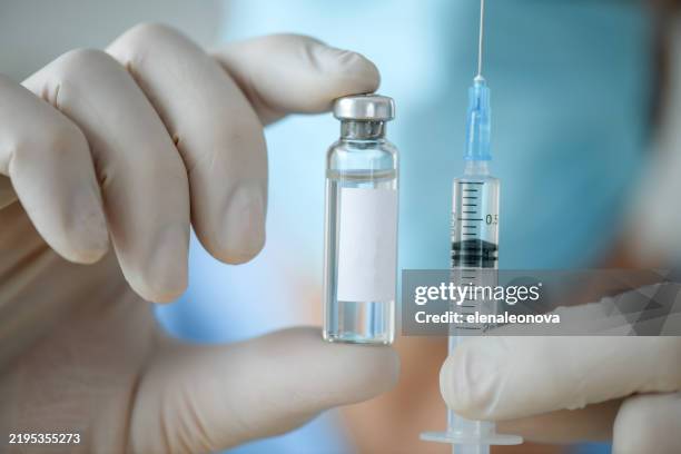 male doctor holding a bottle of medicine for vaccination, for injection - vacina imagens e fotografias de stock
