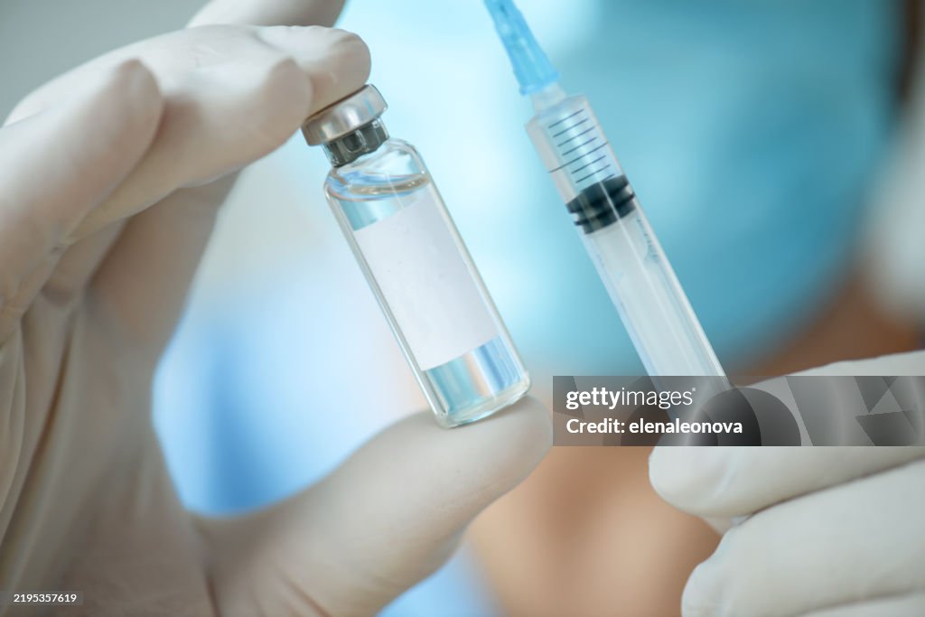 Male doctor holding a bottle of medicine for vaccination, for injection