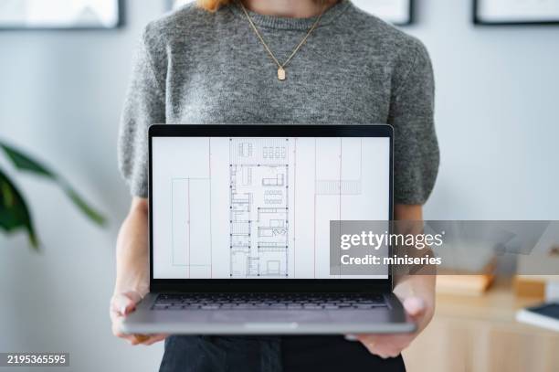 architecte affichant des plans sur l’écran d’un ordinateur portable dans un studio moderne - modèle réduit photos et images de collection