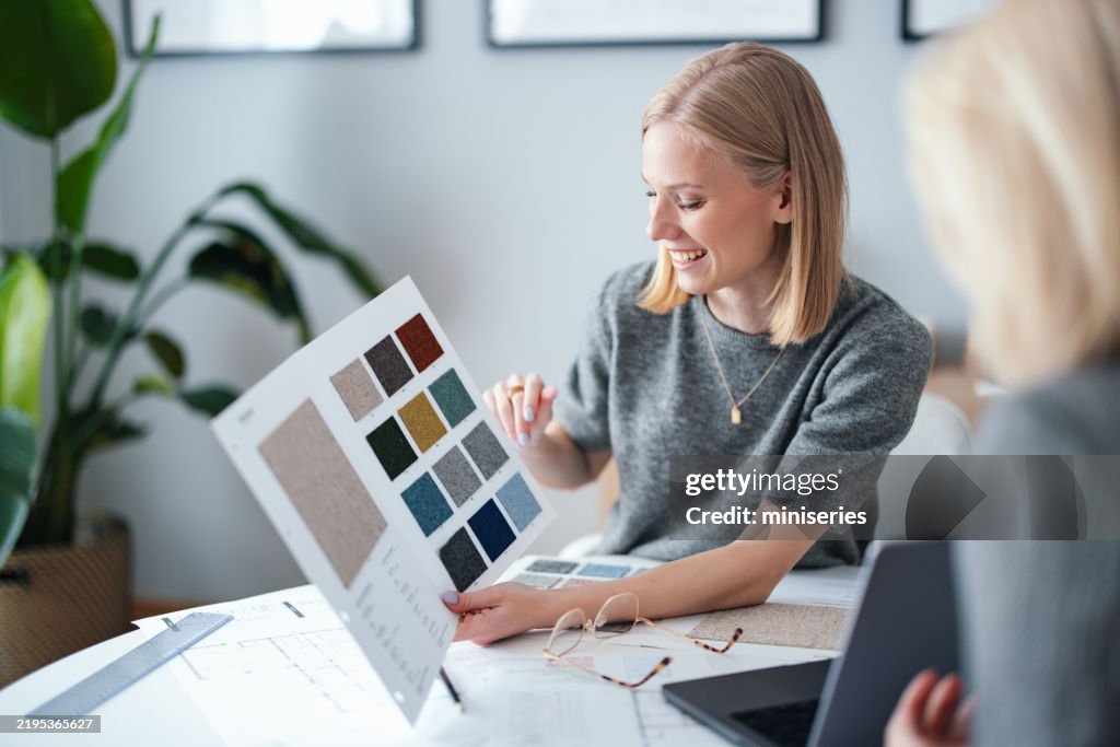 Young Businesswoman Discussing Fabric Sample Selection in Design Studio
