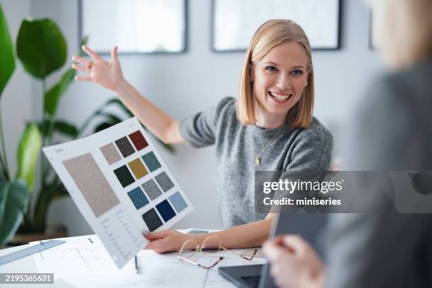 jeune professionnel montrant des échantillons de couleurs dans un studio de design moderne - échantillon de tissu photos et images de collection