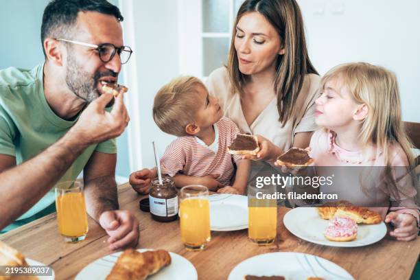 happy family having breakfast - chocolate spread stock pictures, royalty-free photos & images