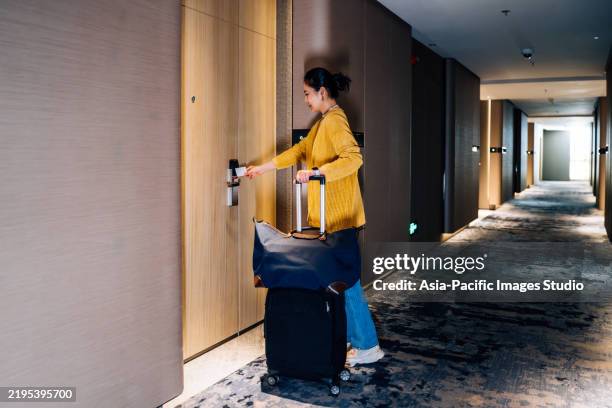 donna d'affari asiatica che apre la porta della sua camera d'albergo con una chiave magnetica dopo il controllo. - ospite foto e immagini stock