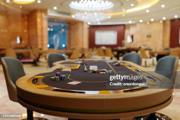 gros plan de la table avec des jetons de jeu et des cartes à jouer dans un casino vide avec un arrière-plan flou - casino interior photos et images de collection