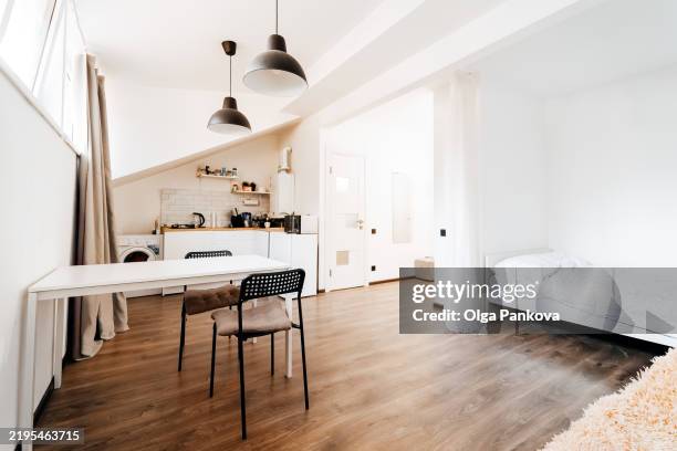 modern open plan studio apartment with kitchen and bed area - studio apartment stock pictures, royalty-free photos & images
