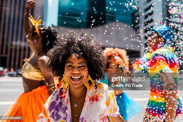 portrait of a mid adult woman having fun with friends at the street carnival - carnaval fotografías e imágenes de stock
