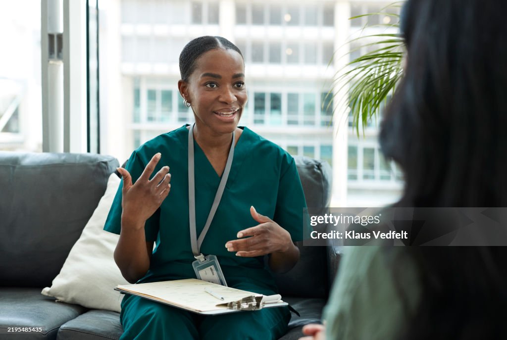 Smiling nurse communicating with patient