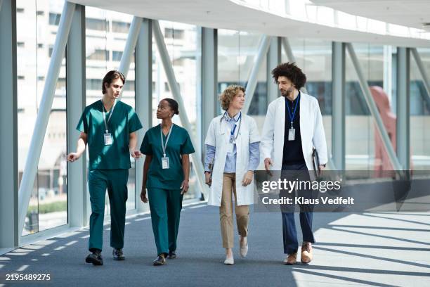 diverse medical staff walking on elevated walkway - medisch beroep stockfoto's en -beelden
