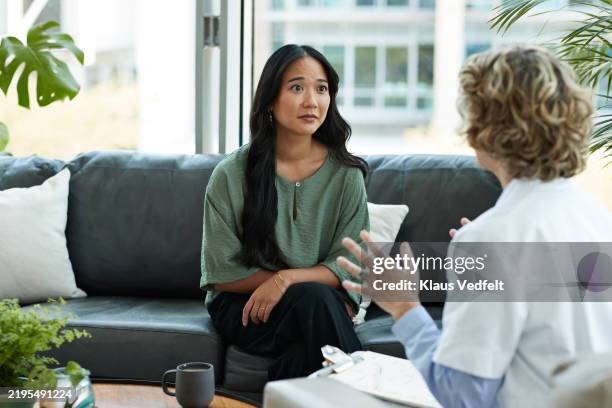 young woman listening to doctor's guidance - patient bad news stock pictures, royalty-free photos & images